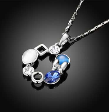 A unique design of combined ornaments plated with platinum, inlaid with white opal, blue glass stone and a crystal diamond